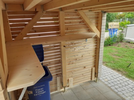 Holzverschlag mit Rhombus aus sib. Lärche in Ständerbauweise mit Dachbegrünung und Schiebetoren für Fahrrad und Mülltonnen
